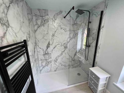 a bathroom with a shower with a marble wall at Country Estate Living 2bed1bath in Silloth