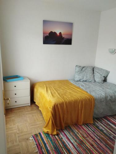 een slaapkamer met een bed met een gele sprei en een dressoir bij porz montroulez in Morlaix