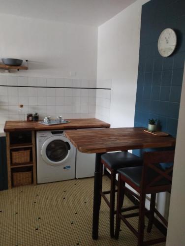 een keuken met een tafel en een wasmachine bij porz montroulez in Morlaix