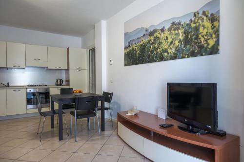 a living room with a television and a table with chairs at Le Porte Blu in Passirano