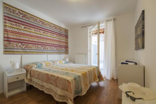 a bedroom with a large bed and a large window at Le Porte Blu in Passirano