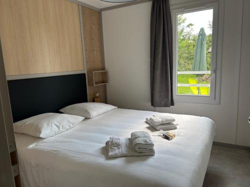 a bedroom with a bed with towels and a window at Erreka pays basque in Hasparren