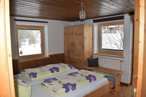 two beds in a room with two windows at Chalet Reiterhäusl in Ramsau am Dachstein