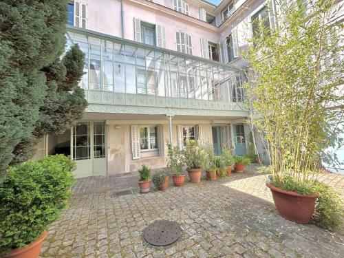 un grand bâtiment avec des plantes en pot devant lui dans l'établissement Appartement lumineux et calme, à Rouen