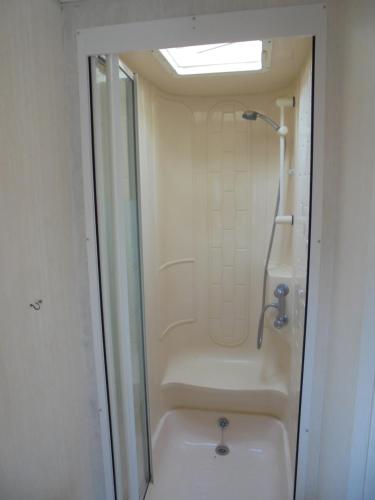 a bathroom with a shower and a bath tub at Promenade: Retreat:- 4 Berth, Access to the beach in Ingoldmells