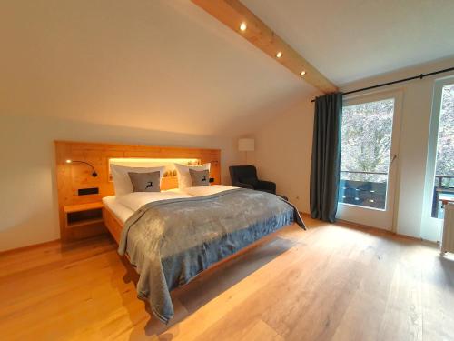 a bedroom with a large bed and a large window at Haus Denneberg in Oberstaufen