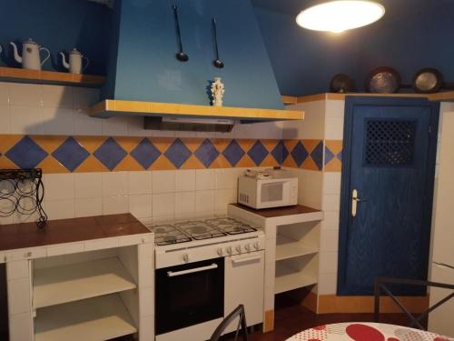 uma cozinha com um fogão e um micro-ondas em AT LA VIÑUELA em Losar de la Vera