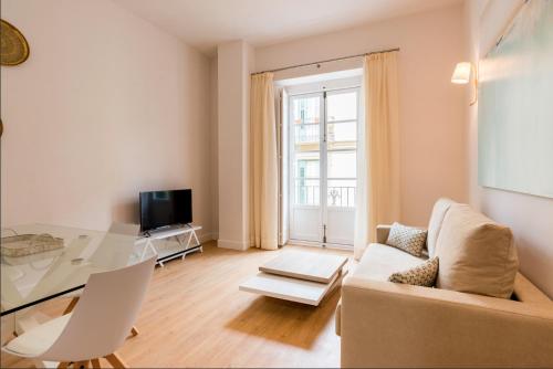 Una sala de estar con una mesa de cristal y un sofá. en Merced10 2C, en Málaga