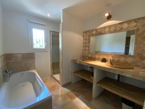 uma casa de banho com uma banheira, um lavatório e um espelho. em Bramasole em Tourtour