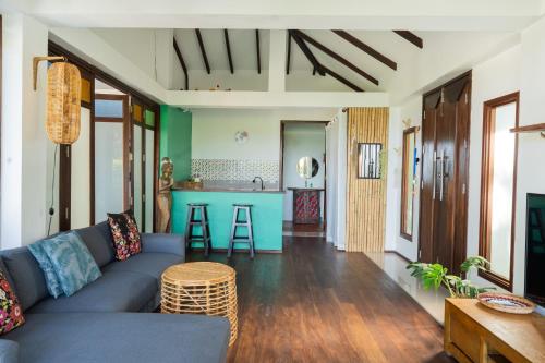 sala de estar con sofá azul y cocina en Banana Villa Koh Tao en Ko Tao
