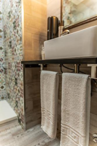 a bathroom with two towels hanging from a sink at Hostal El Bomba in Las Pedroñeras