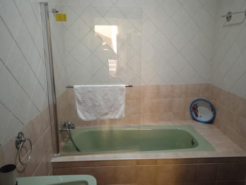uma casa de banho com uma banheira com uma toalha e um chuveiro em AT LA VIÑUELA em Losar de la Vera