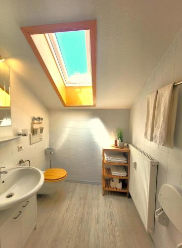 a bathroom with a sink and a skylight at Haus Denneberg in Oberstaufen