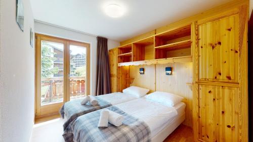 - une chambre avec 2 lits et une grande fenêtre dans l'établissement Pracondu RENOVE OUTDOOR & FUN appartement 2 chambre 6 personnes, à Nendaz