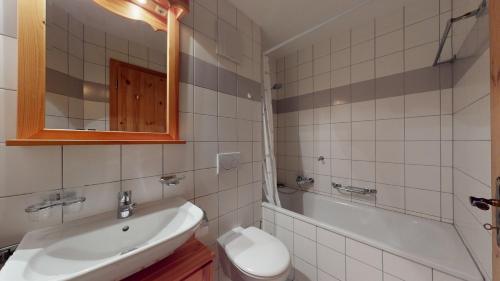 La salle de bains est pourvue d'un lavabo, d'une baignoire et de toilettes. dans l'établissement Pracondu RENOVE OUTDOOR & FUN appartement 2 chambre 6 personnes, à Nendaz