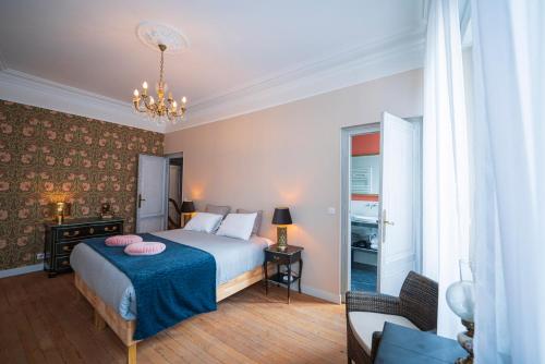 a bedroom with a bed and a chandelier at La Maison Bordeaux in Bordeaux