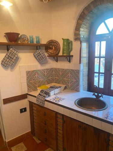 a bathroom with a sink and a window at Superior Stone in Venetico