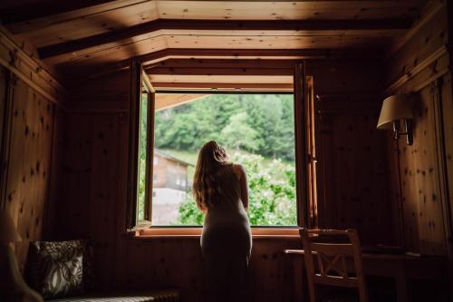 a woman standing in front of a window at Pension Rudolph in Gaschurn