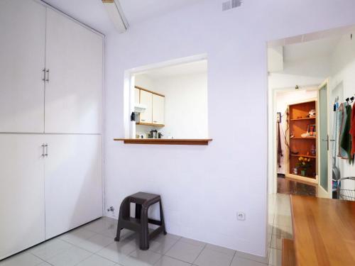 Habitación con armarios blancos y taburete negro en D16241 Sant Telm II, en Sant Feliu de Guíxols