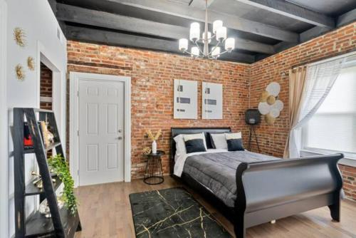 Upscale Luxury Suites Minutes From Center City في فيلادلفيا: غرفة نوم بحائط من الطوب وسرير