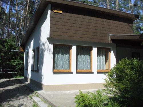 een klein huis met twee ramen en een bruin dak bij Domek letniskowy EWA in Turawa