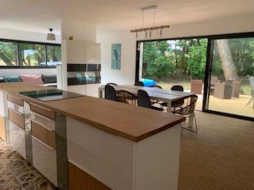 une cuisine et un salon avec une table et une salle à manger dans l'établissement Maison récente cazaux, à La Teste-de-Buch