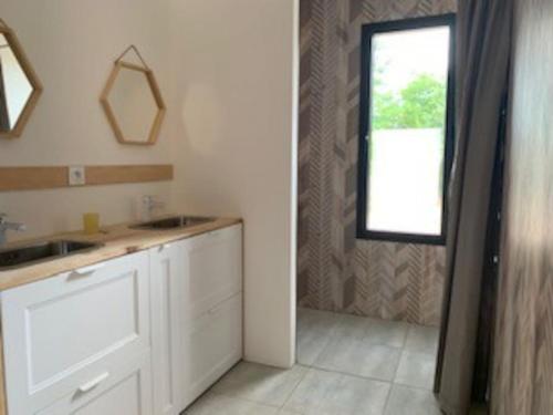 une cuisine blanche avec un évier et une fenêtre dans l'établissement Maison récente cazaux, à La Teste-de-Buch