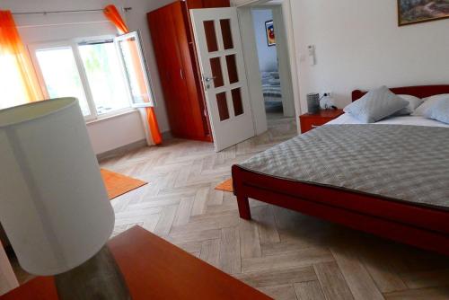 a bedroom with a bed and a wooden floor at Villa Fabry in Ploče