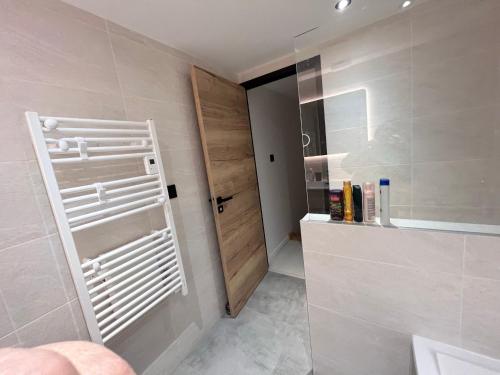 La salle de bains est pourvue d'une porte blanche et d'un lavabo. dans l'établissement Appartement en montagne 90m2 3 chambres, à La Chal