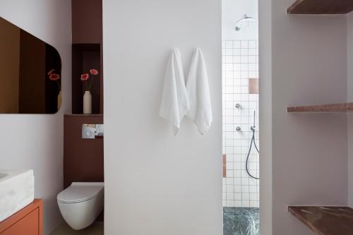 a white bathroom with a toilet and a shower at Nileos House in Athens