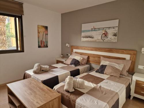 a hotel room with two beds and a table at FUERTEVENTURAPARTMENTS in Corralejo