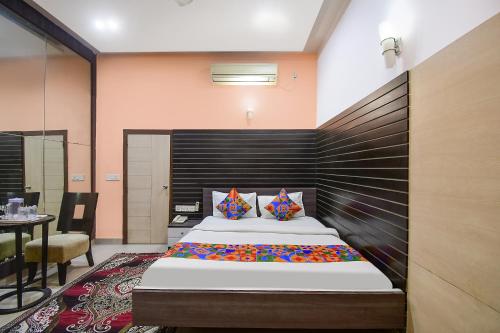 a bedroom with a large bed with a wooden headboard at FabExpress Gardenia in Ballygunge