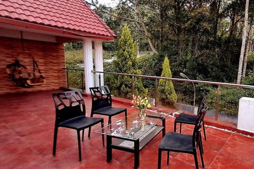 a patio with four chairs and a table and a guitar at iSTAYS - Luxe Villa, Yercaud in Yercaud
