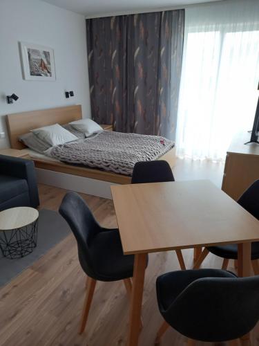 a bedroom with a bed and chairs and a table at Apartmány VLK in Zuberec