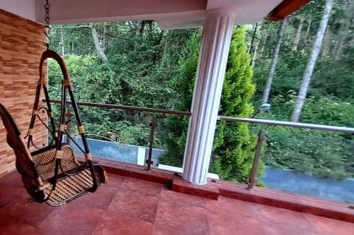a porch with a swing in front of a window at iSTAYS - Luxe Villa, Yercaud in Yercaud