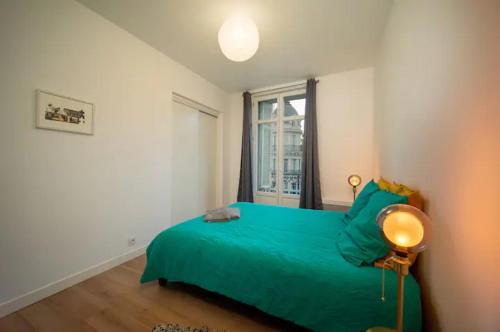 una camera con letto verde e finestra di Magnifique Appartement T4 90 M2 très bien situé 2 min Vieux port et Gare St Charles a Marsiglia