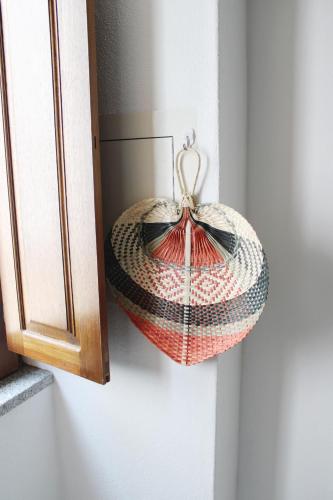 a crocheted basket is hanging on a wall at Casa da Cal Branca in Évora