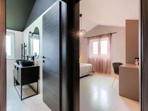 a bathroom with a sink and a room with a bed at Rokvilla in Motovun