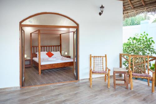 a bedroom with a canopy bed and a mirror at Emerald Dreams Boutique Hotel in Michamvi