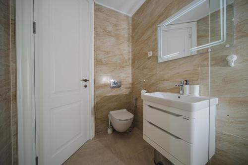 a bathroom with a white sink and a toilet at La barca apartments in Becici