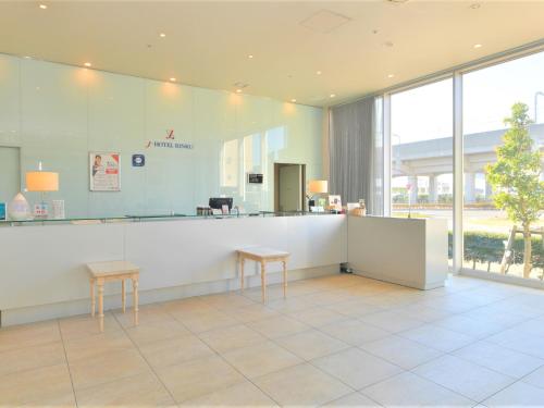 a waiting room with two tables and a counter at J Hotel Rinku in Tokoname