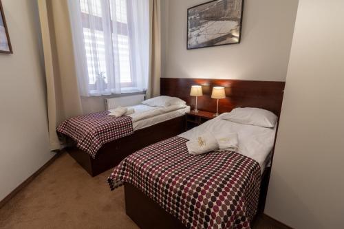een hotelkamer met 2 bedden en een raam bij Atlantic Aparthotel in Krakau