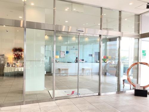 a glass door in a room with a table at J Hotel Rinku in Tokoname