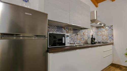 a kitchen with a refrigerator and a microwave at Villa Maria in Mamoiada