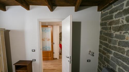 a hallway with a stone wall and a door at Villa Maria in Mamoiada