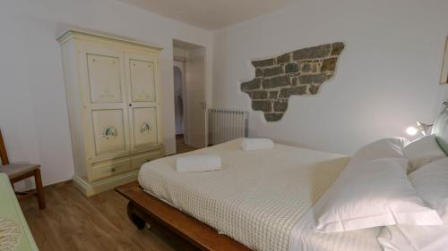 a bedroom with a bed and a dresser at Villa Maria in Mamoiada
