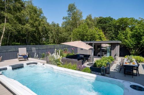 a swimming pool in a backyard with a table and chairs at Moonwood House in Beaulieu
