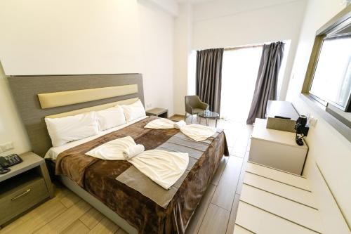 a bedroom with a large bed with pillows on it at Captain Pier Hotel in Protaras
