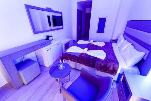 a small hotel room with a bed and a chair at Captain Pier Hotel in Protaras