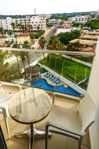a balcony with a table and chairs and a view of a city at Captain Pier Hotel in Protaras